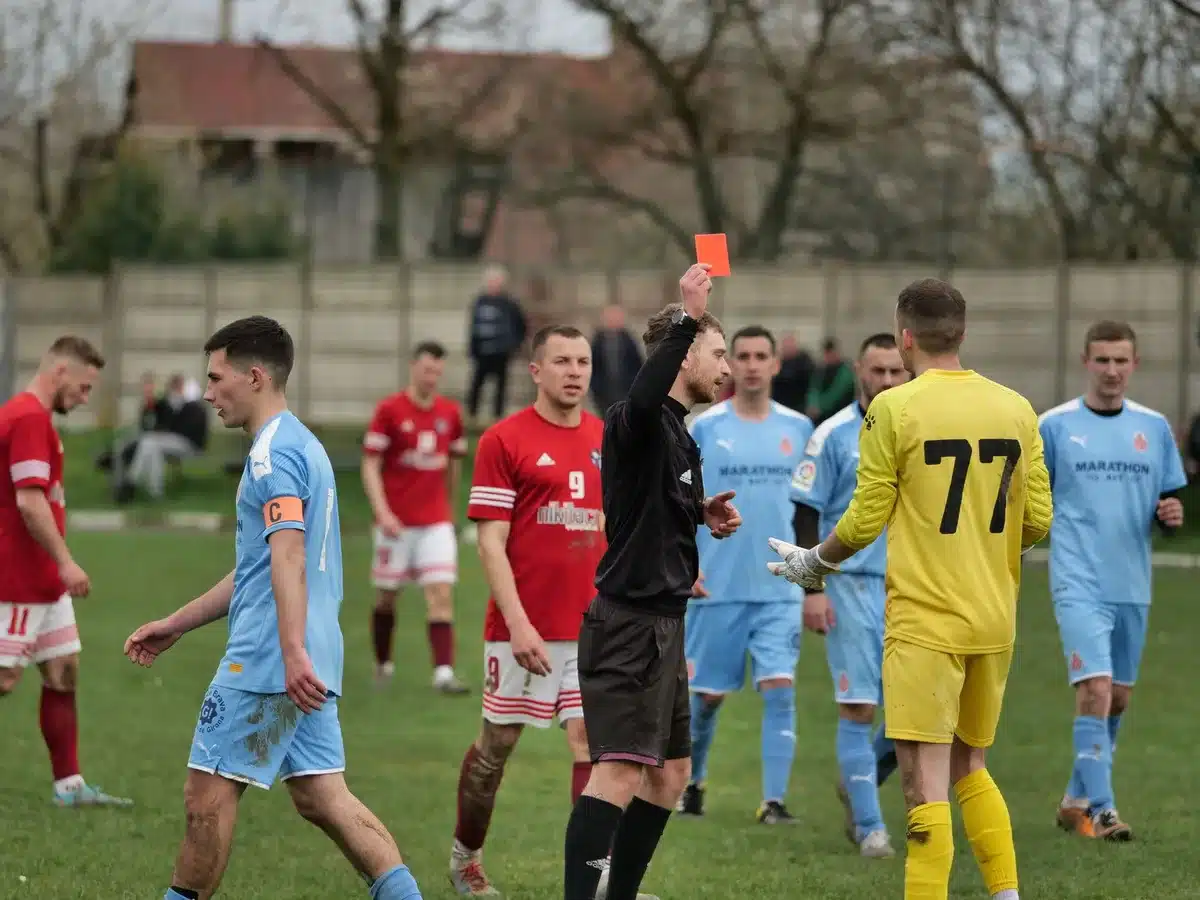 En fotbollsdomare visar gult kort efter en VAR-granskning under en match
