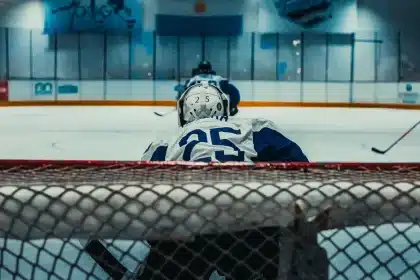 Tv-studio med hockeyutsändning, mikrofon och skärm med spelfilmer