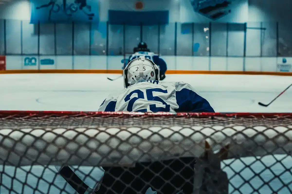Tv-studio med hockeyutsändning, mikrofon och skärm med spelfilmer