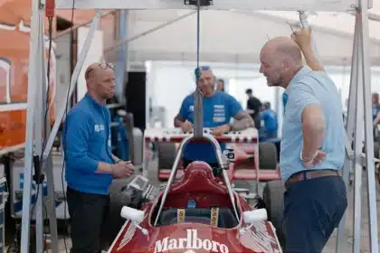F1-garage med racingkläder och telemetri-skärmar på arbetsbänk