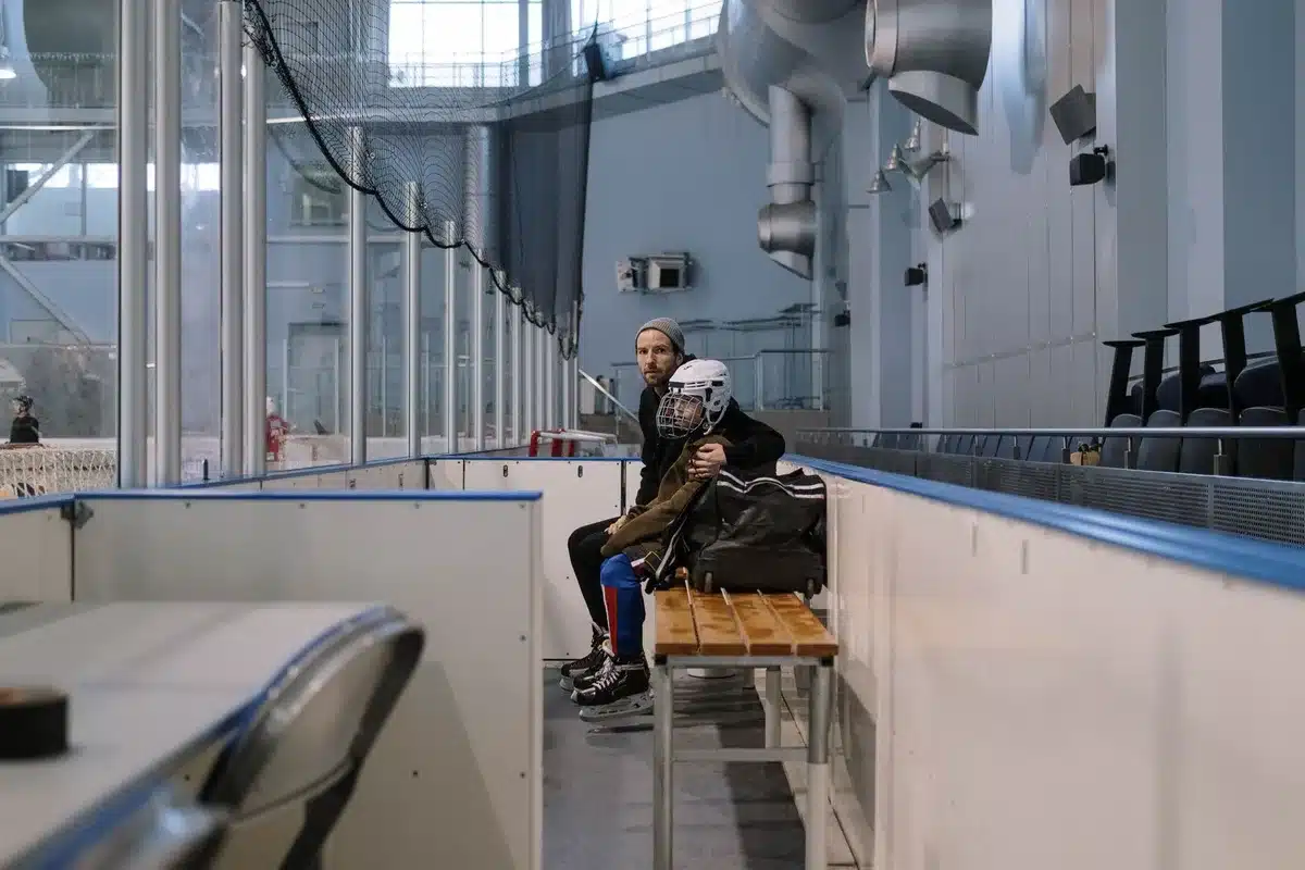 Ishockeytränare övervakar träning på isen med fokuserad blick