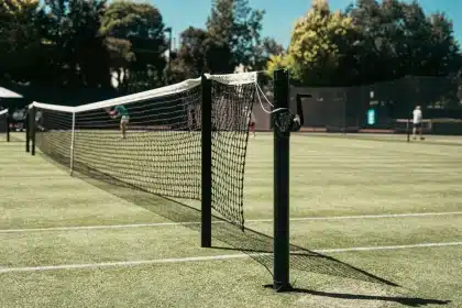 Två tennisspelare under intensiv rally på gräsbana under stor match