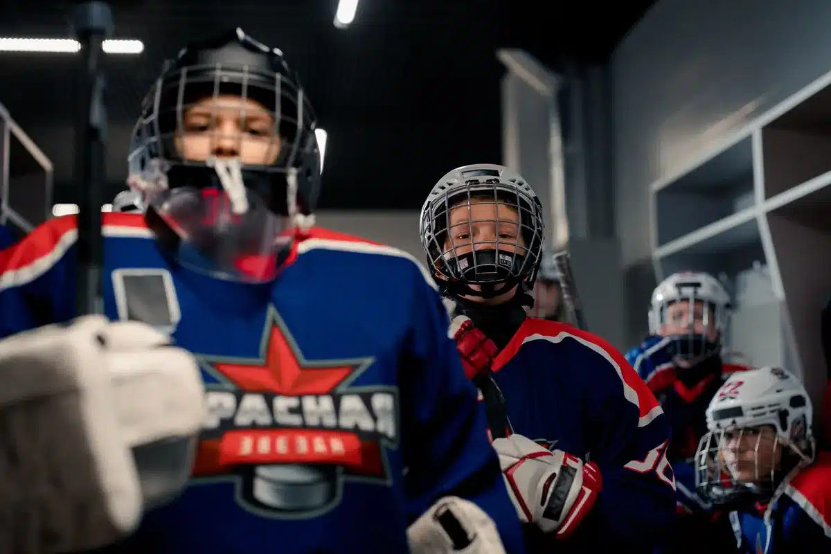 Ishockeylag samlat i omklädningsrummet med fokuserade uttryck innan match