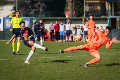 Fotbollsmatch under intensiv spel med spelare i rörelse och anspänd atmosfär