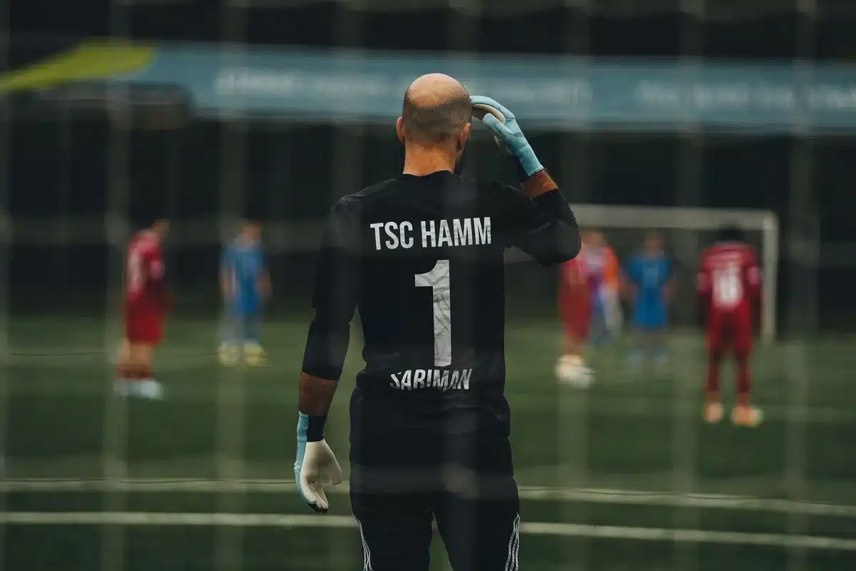 En fotbollsspelare i en tom stadion efter en förlorad match, med huvudet nedbört och axlarna böjda av besvikelse.