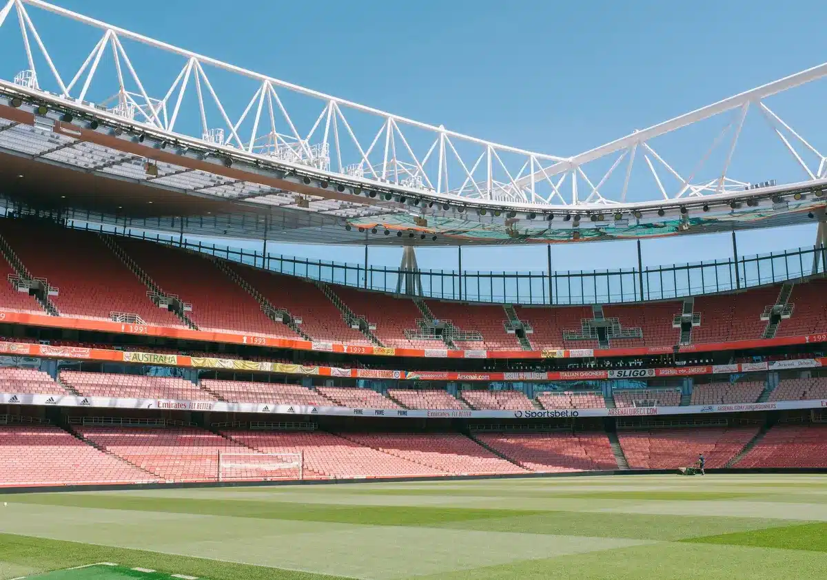 Fotbollsstadion med ranking-poäng och lagmärken synliga på grässmattan